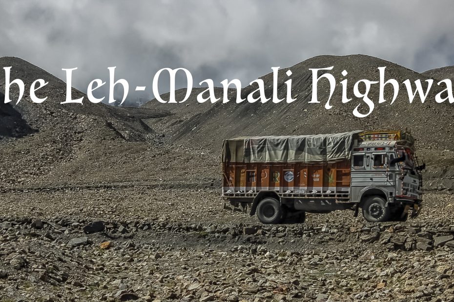 A travel blog featuring a truck traversing the rugged terrain of the Leh-Manali highway with mountains in the background.